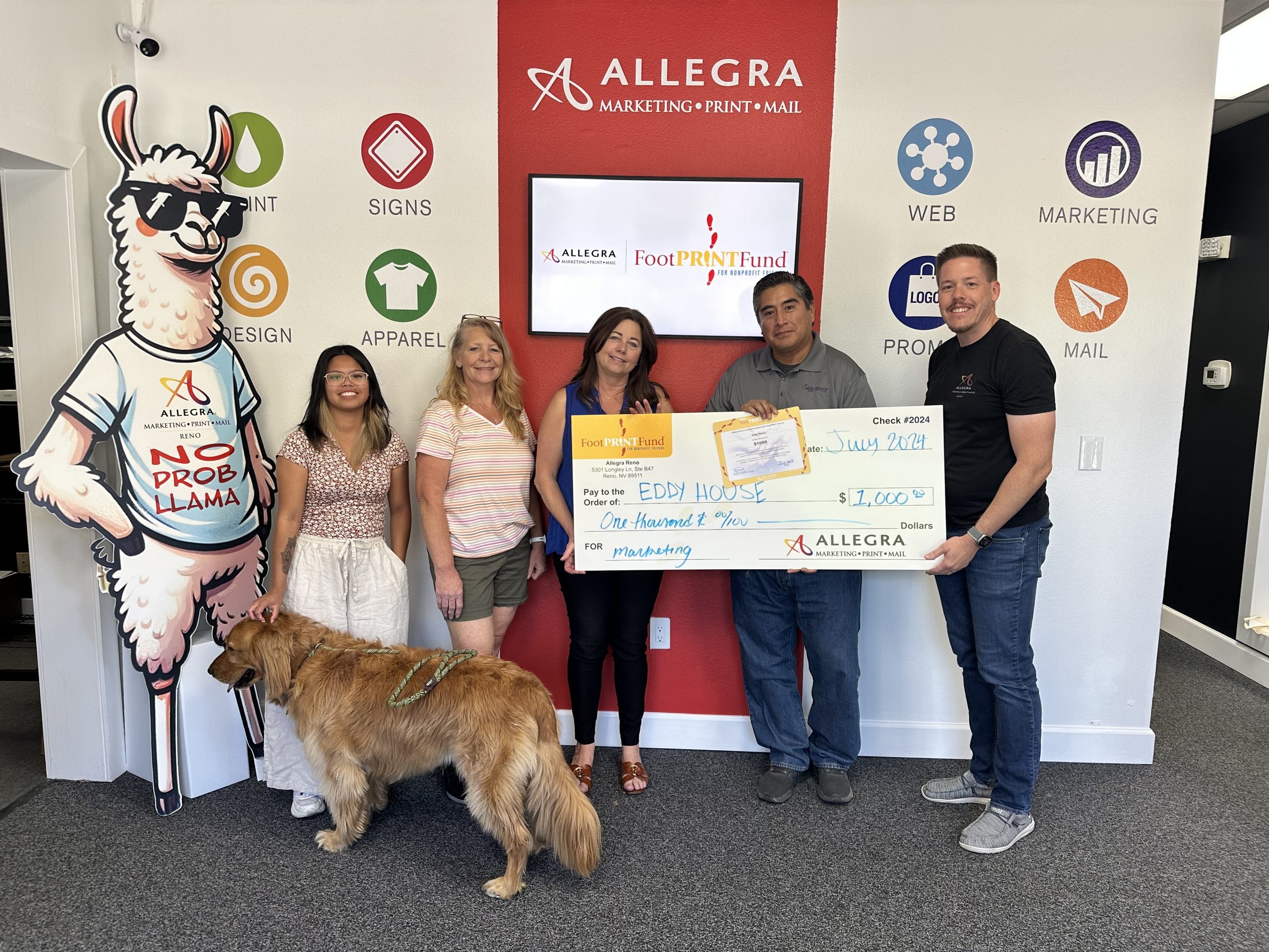 Eddy House team accepts grant from Allegra team, alongside a staff's pet golden retriever.