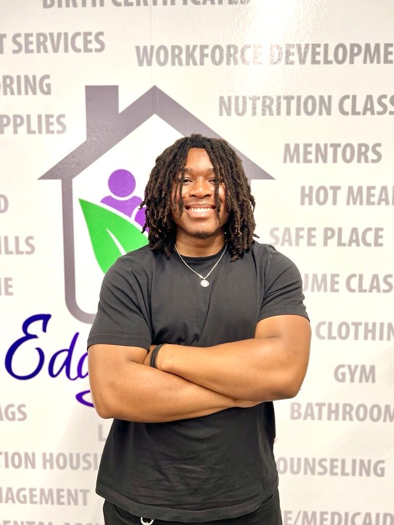 Gilbert smiling in front of Eddy House backdrop.