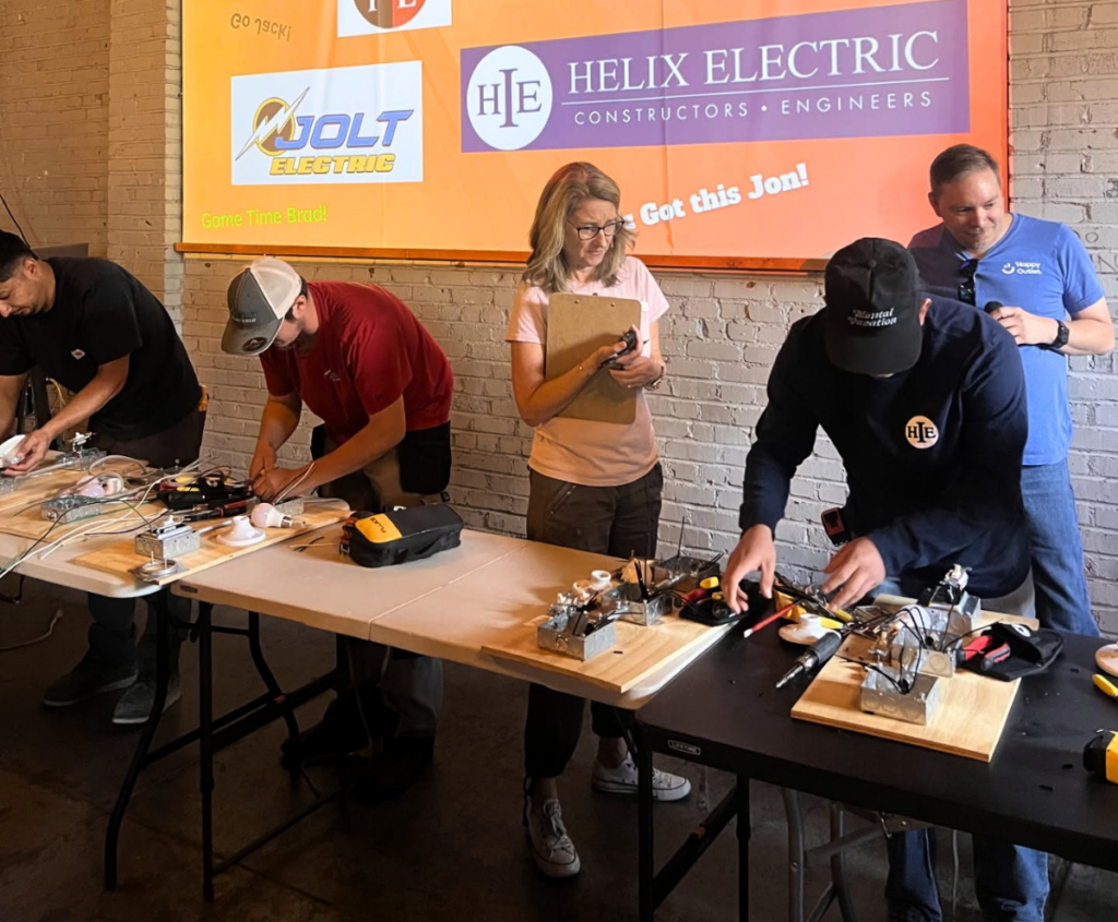 Electrical apprentices complete hands-on wiring projects as a judge observes during the Northern Nevada IEC Electrical Apprentice Competition.