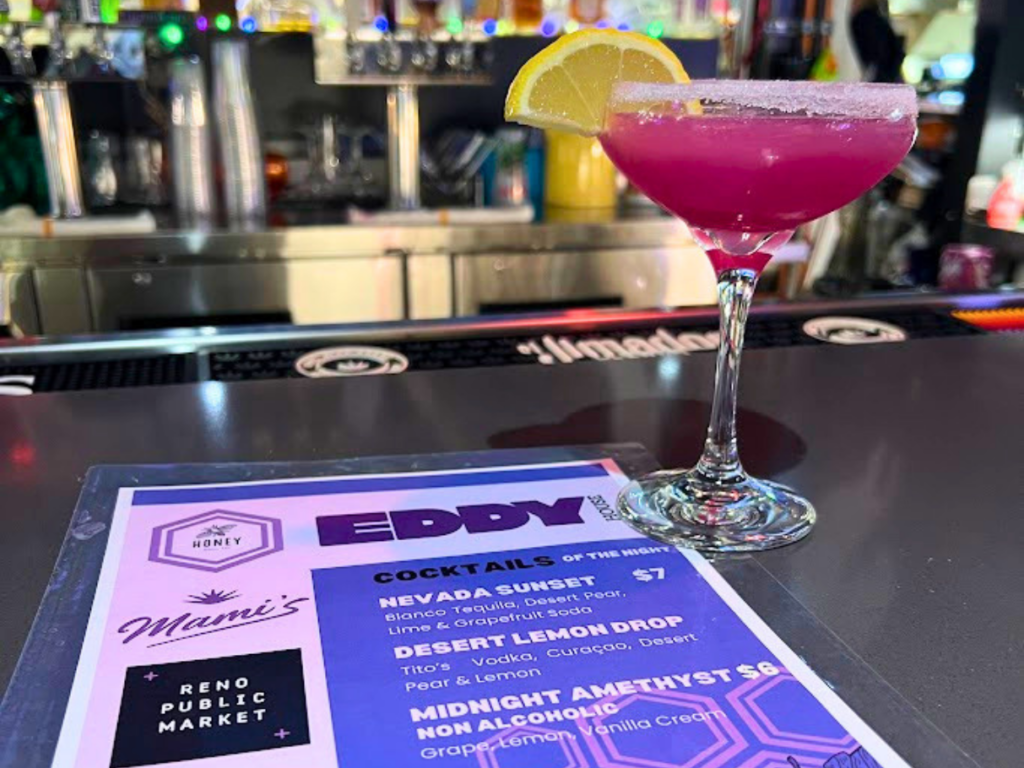 urple cocktail beside Honey Bar’s special drink menu at Reno Public Market during Eddy House’s 2025 National Homeless Youth Awareness Month kickoff, where every dollar from featured cocktail and nonalcoholic drink sales was donated to Eddy House.